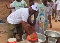 Pius Hadzide (in white attire) washing clothes