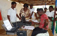 An EC official taking some residents through the registration process