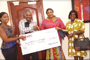 First Lady, Rebecca Akufo-Addo takes a check of GHC10,000 from KFC management.