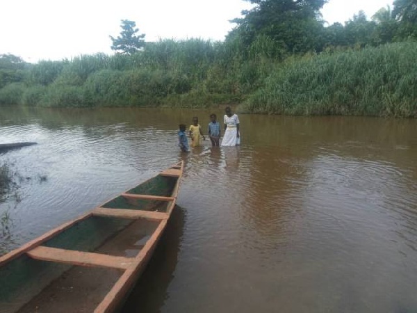 Some pupils crossing the Densu River to school