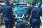 Police carrying a dead body in a body bag