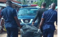 Police carrying a dead body in a body bag