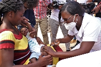 A nurse administering a malaria vaccine to a child to mark the beginning of the expanded immunizatio