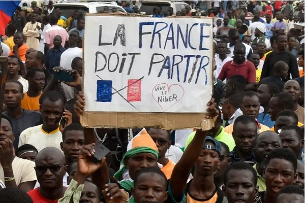 Protesters hold an anti-France placard during a demonstration on independence day in Niamey
