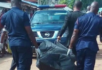 Police officers seen holding a body bag