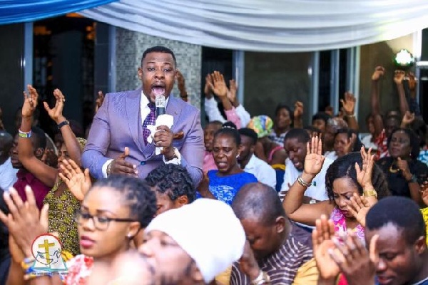 Prophet Nigel praying for his church members