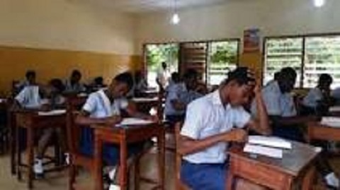 Students busily writing their BECE exams