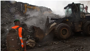 Rescue workers search through a heap of refuse after it collapsed at Conakry’s largest landfill