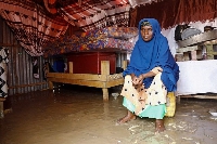 Fatima Abdi, 50, an internally displaced Somali woman, sits inside her flooded makeshift shelter