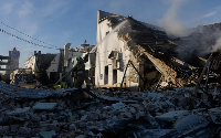 Firefighters extinguish a blaze at a Kyiv car dealership after Russian strikes on Ukraine