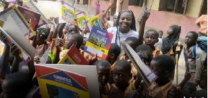 Ida Alira Adiyone in a group photo with school children