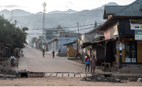 Congolese civilians walk after returning to their homes following displacement during  clashes