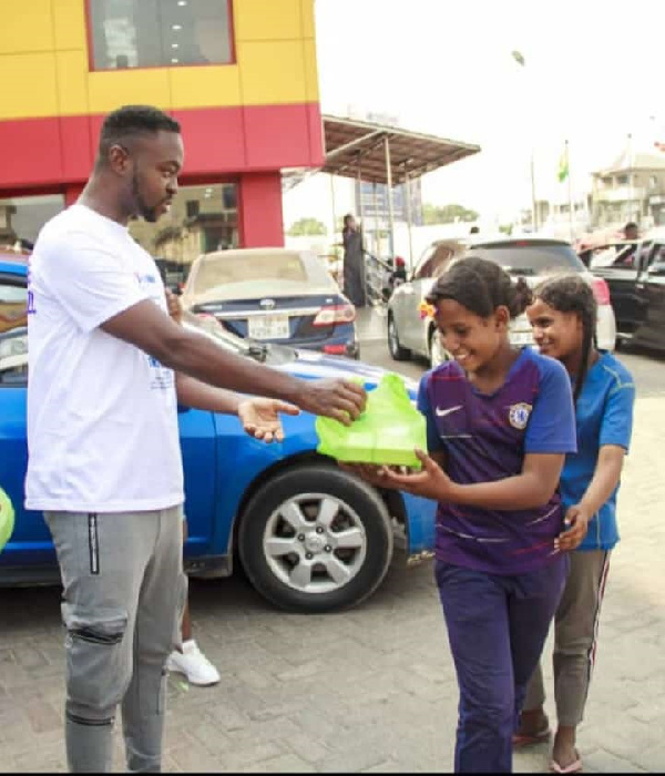 William Nana Yaw Beeko presenting a package to one of the beneficiaries