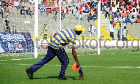 Soccer fan sweeping the field with a broom before the commencement of a match