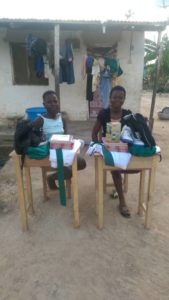 Faustina and Juliana happily show-off their new uniforms and other items