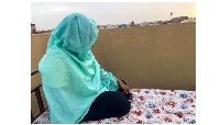 A woman checks her phone for news of her relatives during the conflict in Khartoum, Sudan