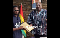 Former President Mahama (right) presenting the cash sum to a member of Buzzstop Boys