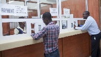 A customer paying bills at the ECG office