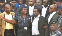 Alistair Nelson standing between his lawyer and a police officer