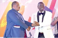Managing Director of ECG (right) receiving the award from one of the organisers of the event