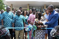 Madam Akosua Frema Osei-Opare cutting the ribbon to mark the handing over of the vehicles