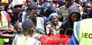 Security personnel help a woman who fainted as pilgrims jostled for 'holy' water