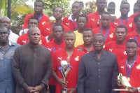 The team presented the trophy to the late President Mills (Second in black from right)