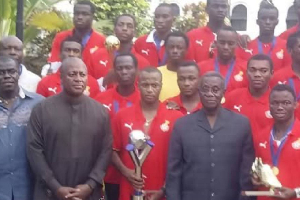 The team presented the trophy to the late President Mills (Second in black from right)