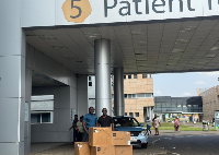 A member of the UGMC takes a picture with the medical supplies received from MedDrop Box Inc