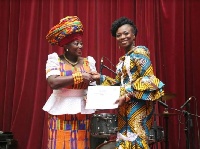 Akumaa Mama Zimbi presenting the award to Ghanaian TV personality Stacy Amoateng