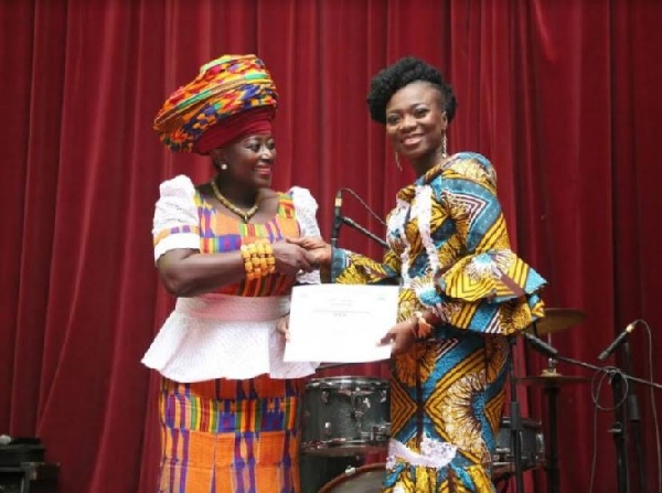 Akumaa Mama Zimbi presenting the award to Ghanaian TV personality Stacy Amoateng