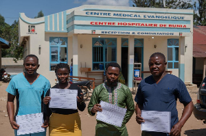 Healthcare workers and patients pose with their certificates after recovering from Ebola in Beni