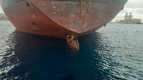 Three stowaways are shown perched on the rudder of the oil and chemical tanker Althini II