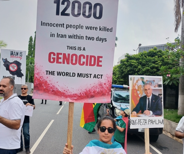 A lady holding placards reading; 12000 Innocent people were killed in Iran within two days