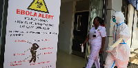 Health workers and officials walk outside a Ebola isolation facility at The Nairobi Hospital