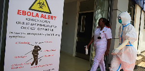 Health workers and officials walk outside a Ebola isolation facility at The Nairobi Hospital