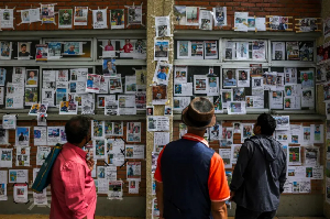 People view photos of those missing after deadly floods and mudslides in Kathmandu, Nepal