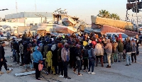 Migrants wait at Sfax port, after being stopped by Tunisian coast guard at sea during their attempt
