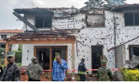 Army and firefighters work at a house damaged by a drone strike in Goma