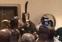 Okyenhene, with a sword, issuing the warning