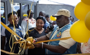 Allotey-Gaisie (right) being assisted by other officials to cut the tape to inaugurate the facility