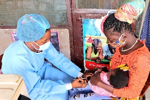 A health practitioner immunising a child