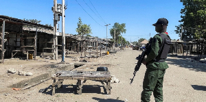 A Nigerian police officer stands guard outside the Al-Adum Jumaat Mosque