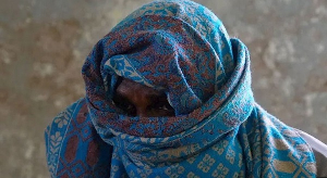 Two Somali fishermen wearing big scarves over their heads to hide their faces