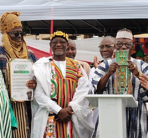 Sarki Musah Yahaya Yendu (L) presenting a citation to Baba Lamin (M) at the event