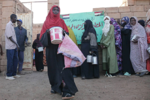 A woman carries food as she leaves a charity kitchen in Khartoum, Sudan