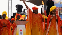 Senegalese basketball legend Mame Maty Mbengue lights a torch from the cauldron during a ceremony