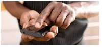 File photo of a man pressing on his mobile phone