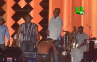 Shatta kneeling before Mr. Kennedy Agyapong on stage