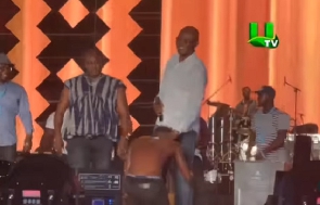 Shatta kneeling before Mr. Kennedy Agyapong on stage